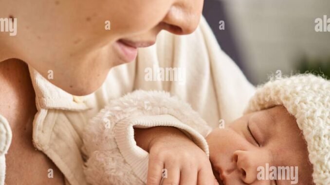 beautiful-joyful-mother-in-homewear-holding-lovingly-her-newborn-baby-boy-modern-parenting-2WCAMFG
